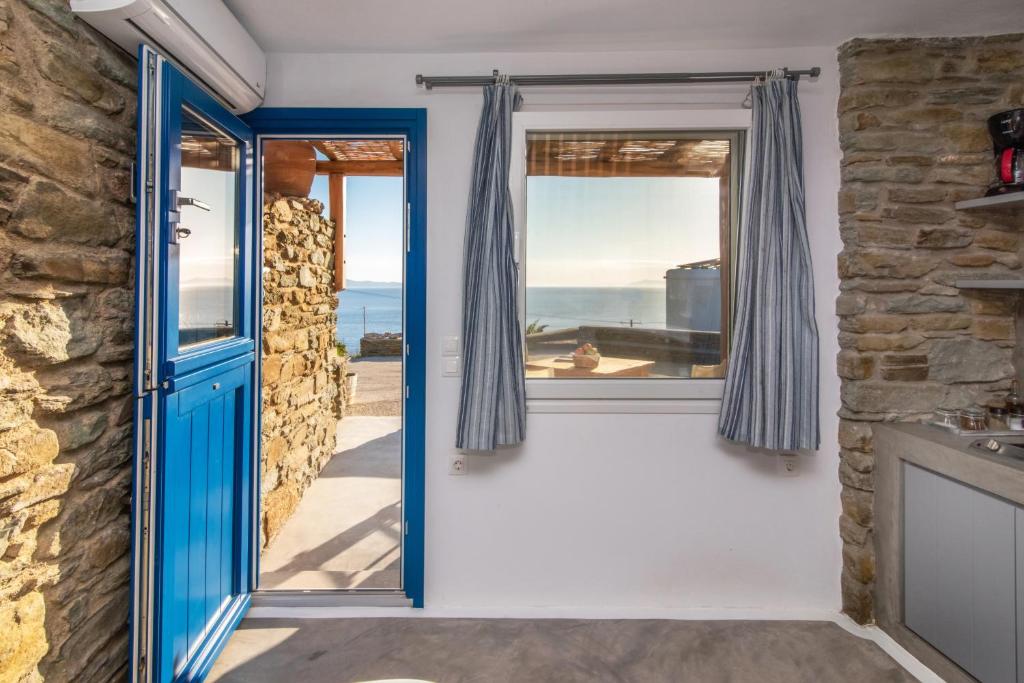 uma porta que leva à cozinha com vista para o oceano em Avissalou Apartments em Agios Romanos