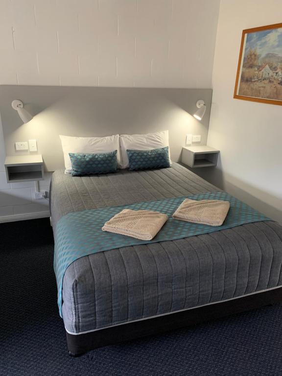 a bedroom with a bed with two towels on it at Glen Innes Motel in Glen Innes