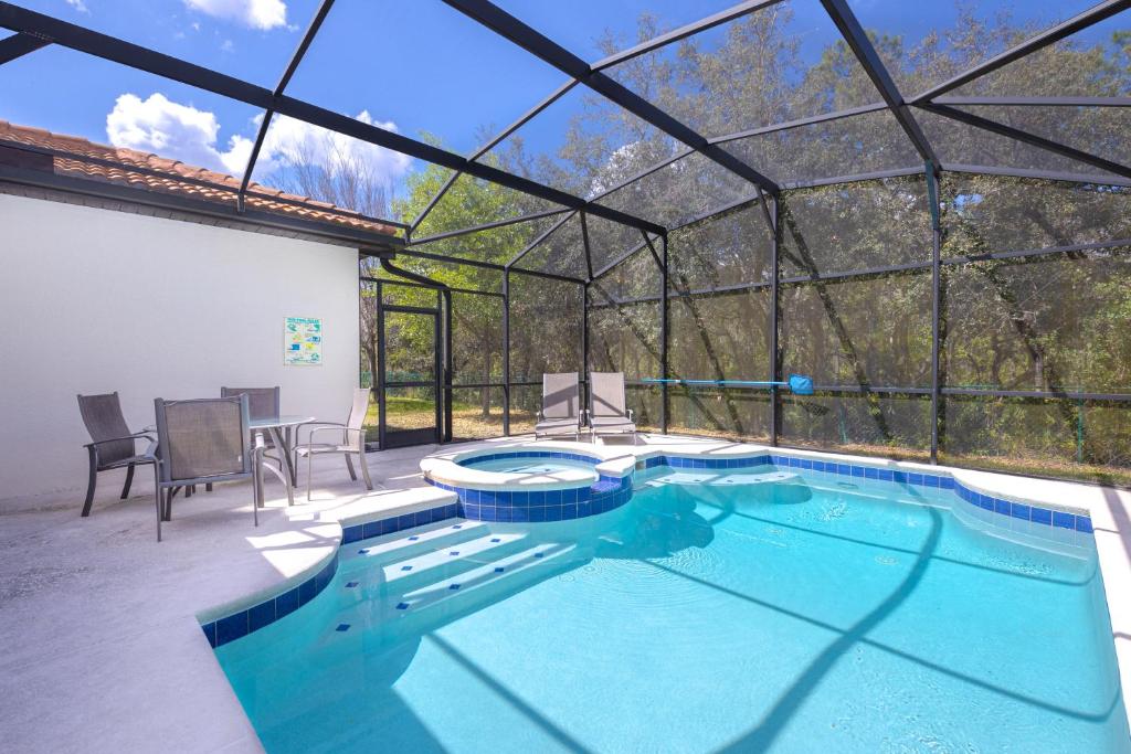 una piscina cubierta en una casa de cristal en Newly Remodeled 1 story - 5 Bed 5 Bath with Pvt Pool Spa And Game Room, en Kissimmee