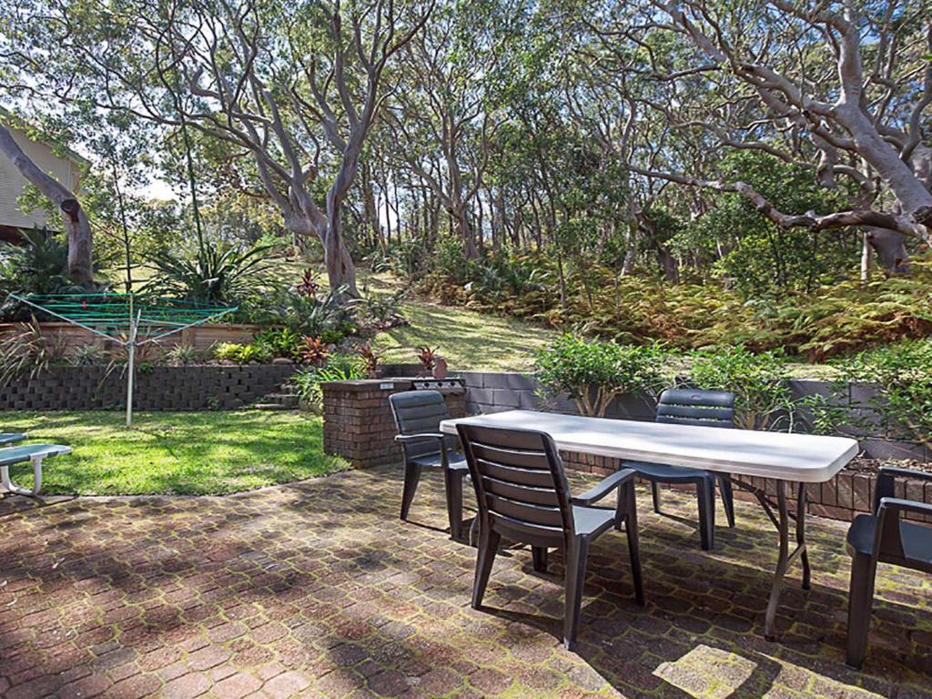 a patio with a table and chairs in a yard at Adriana 3 unit with a backyard in Shoal Bay