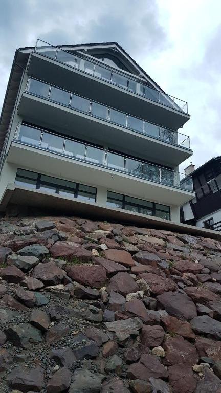 a tall building with a stone wall in front of it at Apartamenty KADO (MATEJKI) in Karpacz
