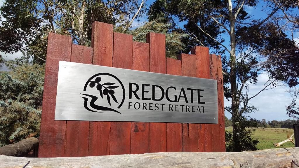 un panneau indiquant une retraite forestière sur une clôture en bois dans l'établissement Redgate Forest Retreat, à Witchcliffe