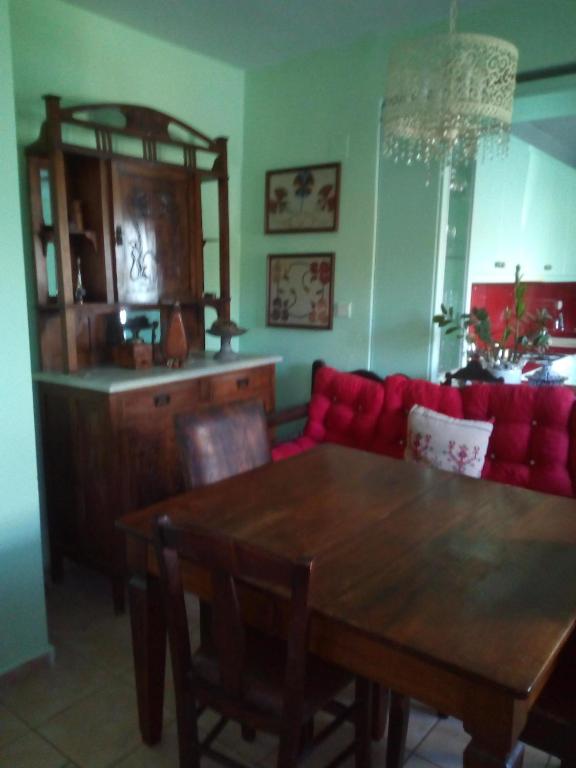 een woonkamer met een houten tafel en een rode bank bij Εξοχικό σπίτι ΚΑΝΤΗΡΑΚΑΣ in Gythio