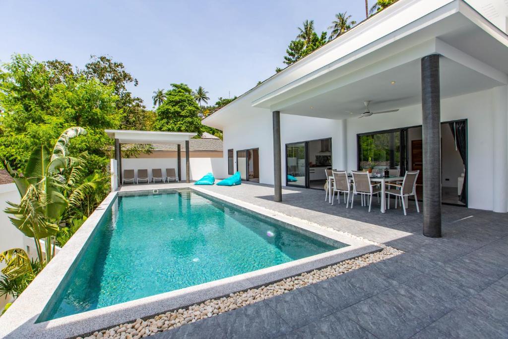 a swimming pool in the backyard of a house at Villa Nirvana, 3 Bedrooms, Chaweng Noi in Koh Samui 