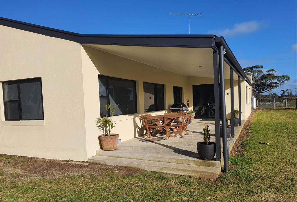 a house with a black roof and a wooden patio at Pleasant Hill BnB in Mount Gambier