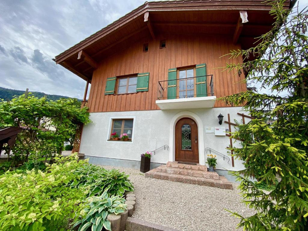 een houten huis met een deur en een balkon bij HAUS Alpenoase in Schönau am Königssee