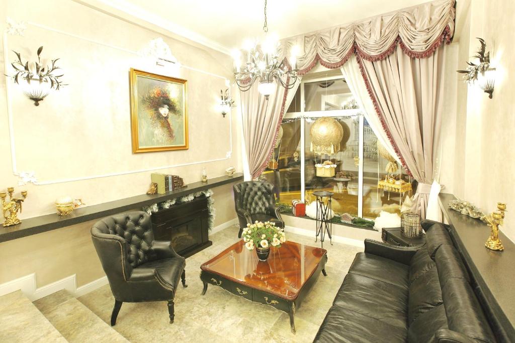 uma sala de estar com um sofá, cadeiras e uma mesa em Excelsior Boutique Hotel Sinaia em Sinaia