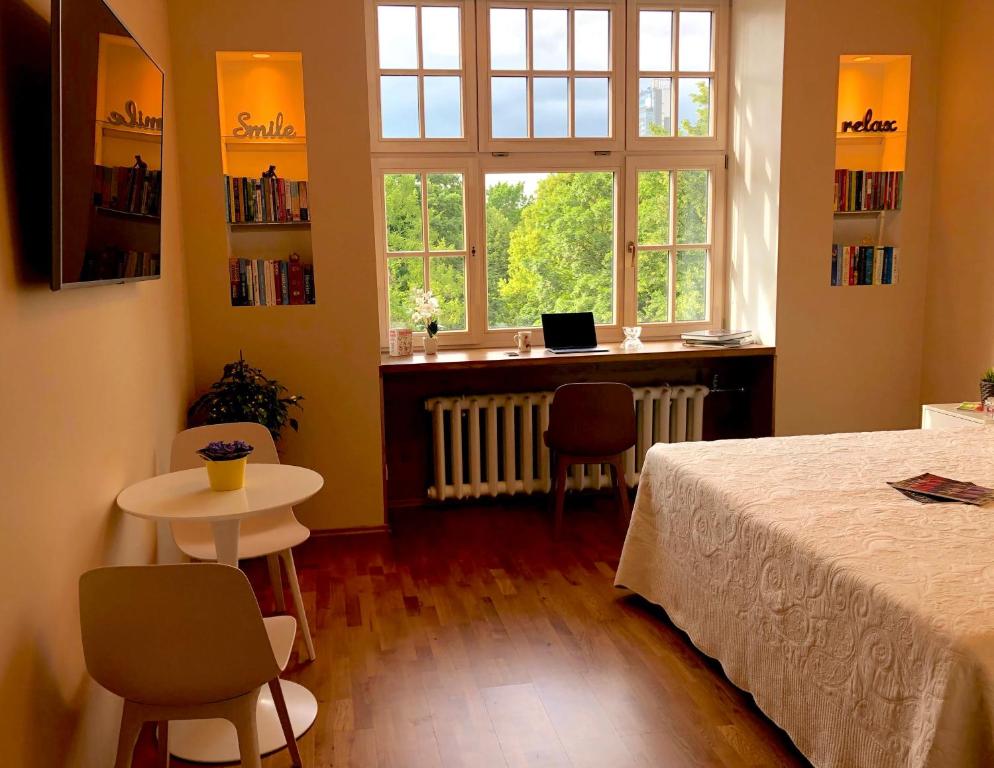 - une chambre avec un lit, un bureau et une fenêtre dans l'établissement Centrally located apartment overlooking Vermanes Park, à Riga