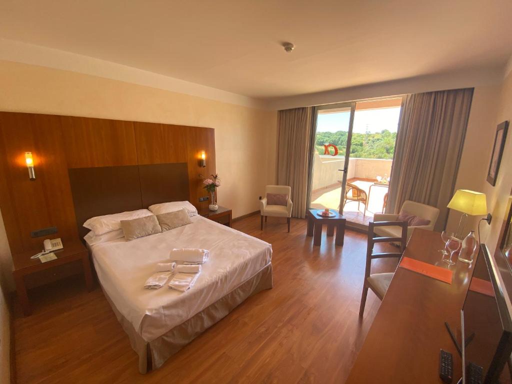 a hotel room with a bed and a dining room at Hotel Montera Plaza in Los Barrios