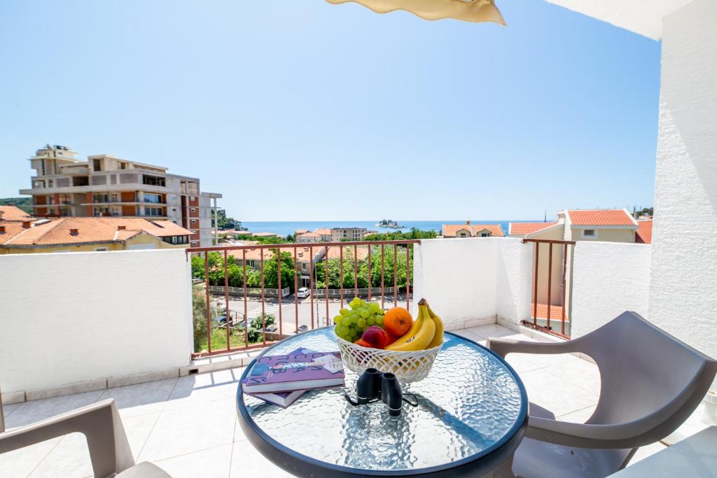 a bowl of fruit on a glass table on a balcony at Apartments Vjera Petrovac in Petrovac na Moru
