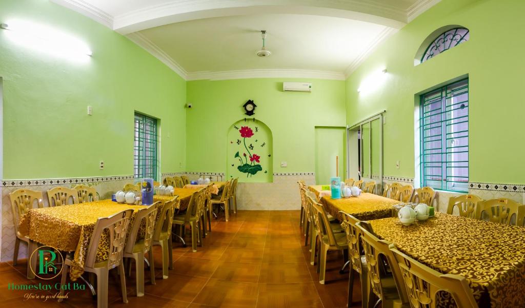 a banquet hall with tables and chairs in a room at Pi's Homestay CatBa in Cat Ba