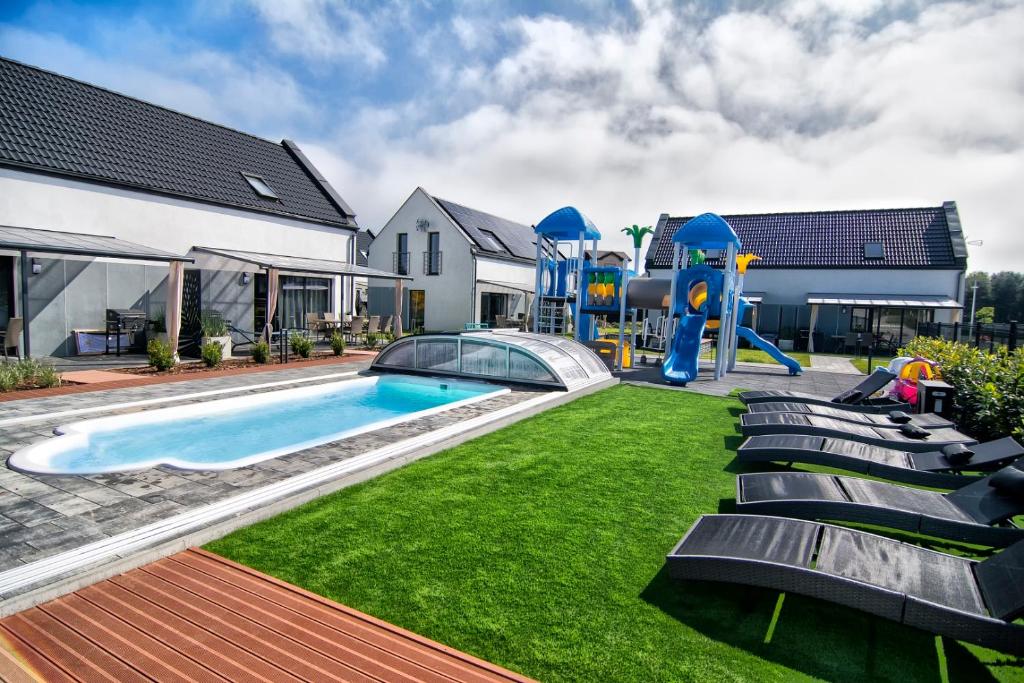 a backyard with a pool and a playground at Nadmorski Zaułek in Jastrzębia Góra