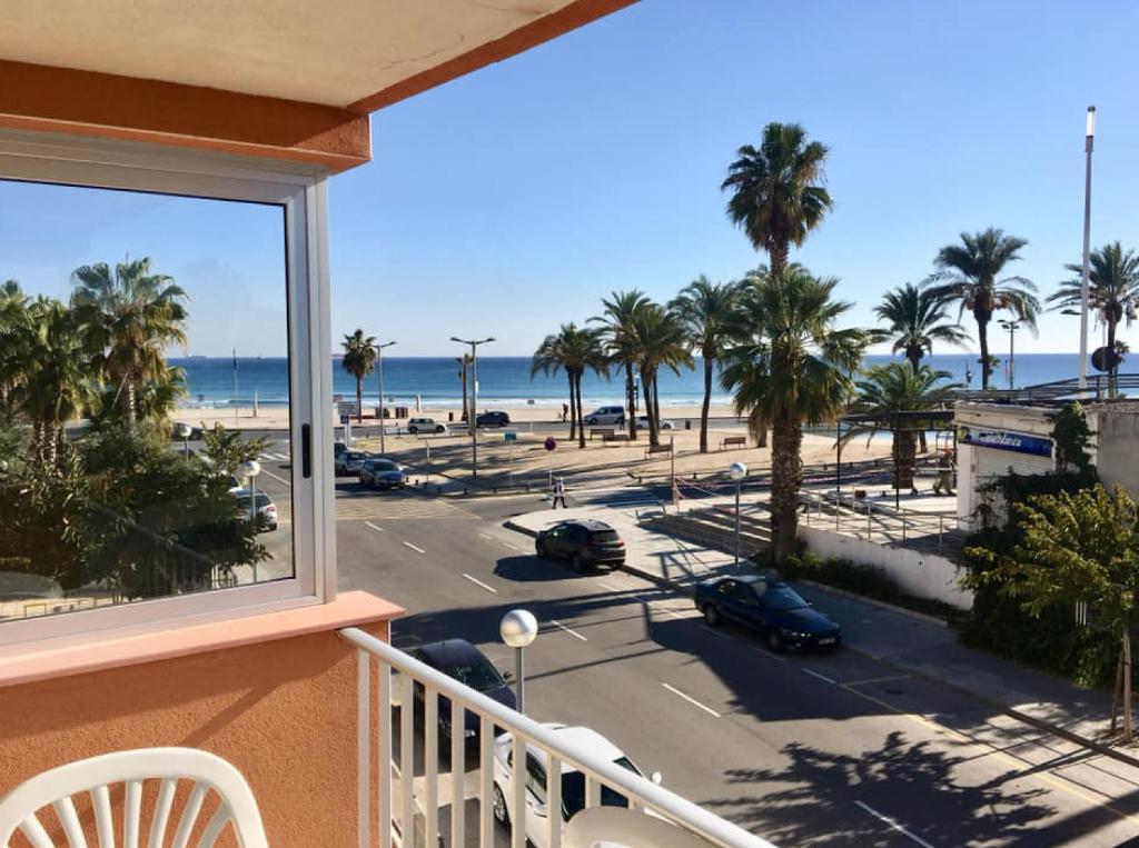 einen Balkon mit Blick auf den Strand und die Palmen in der Unterkunft SUN and BEACH LOVERS 12019 in La Pineda