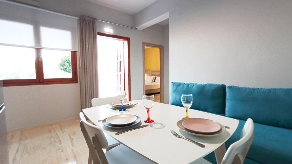 ein Esszimmer mit einem weißen Tisch und einem blauen Sofa in der Unterkunft Plakias Riviera in Plakias