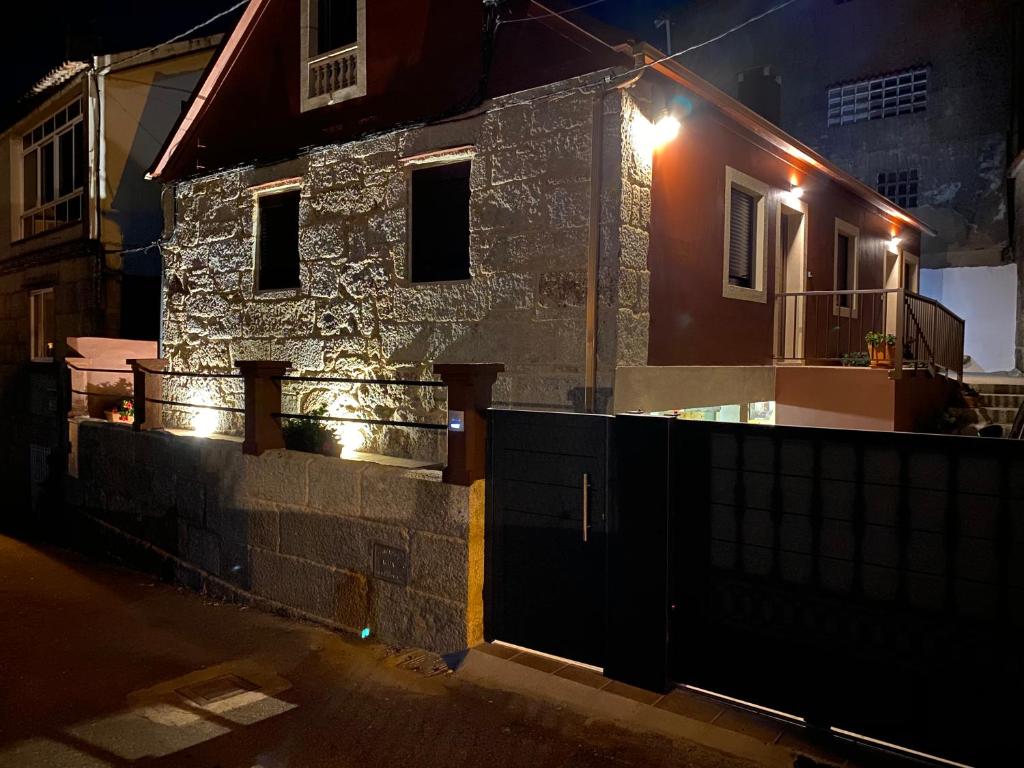 een huis met een hek en 's nachts een hek bij Apartamento Casa Xesteira in Poio