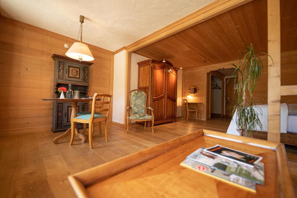 ein Wohnzimmer mit einem Tisch und Stühlen im Zimmer in der Unterkunft Hotel Alpenrose mit Gourmet-Restaurant Azalée in Gstaad