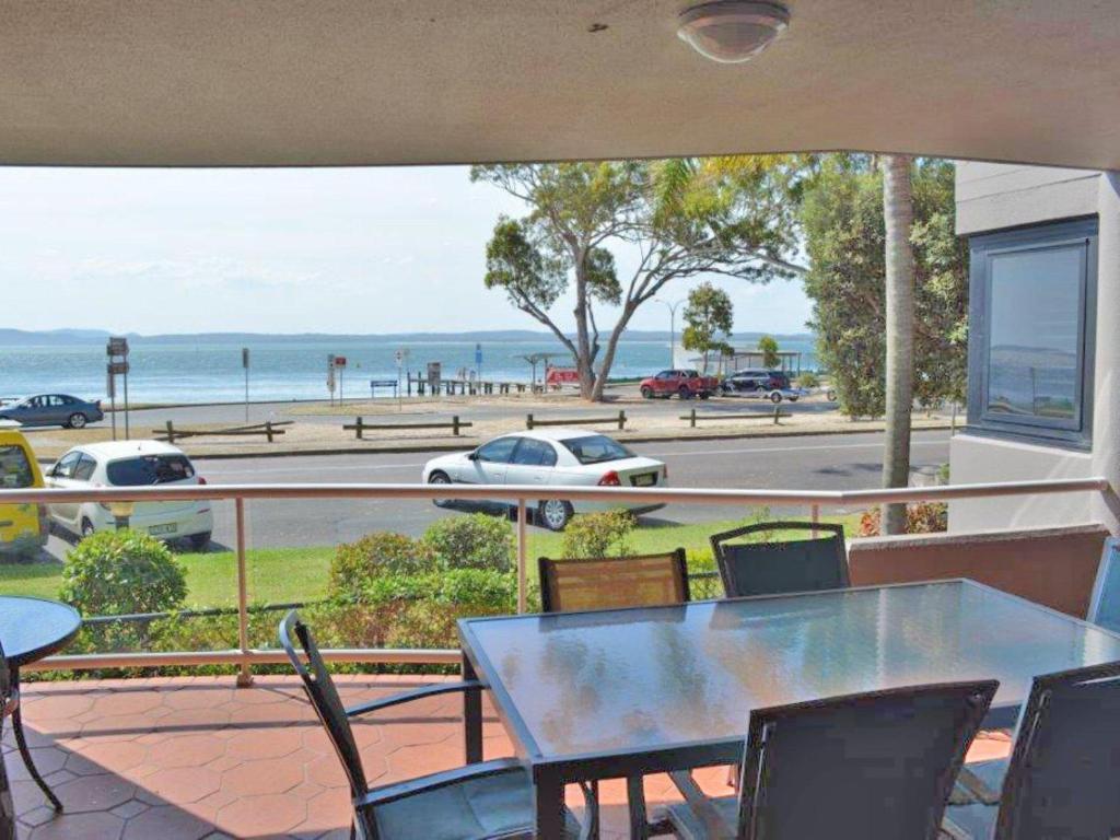 a patio with a table and chairs and a view of the ocean at Florentine 4 spectacular views and air conditioning in Nelson Bay