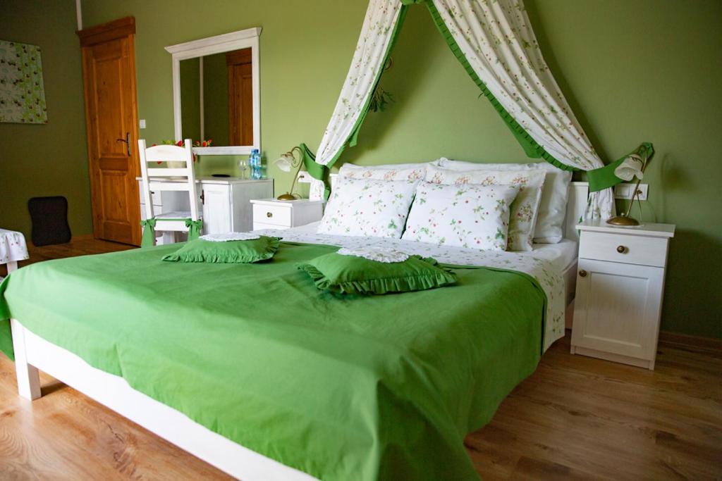 a bedroom with a green bedspread and a white bedspread at Górski Raj in Wisła