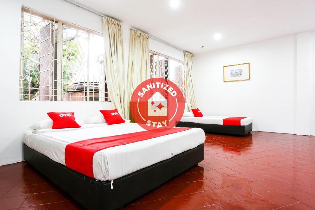 a bedroom with two beds and a sign on the wall at OYO 89562 Hotel Shalimar in Kuala Lumpur