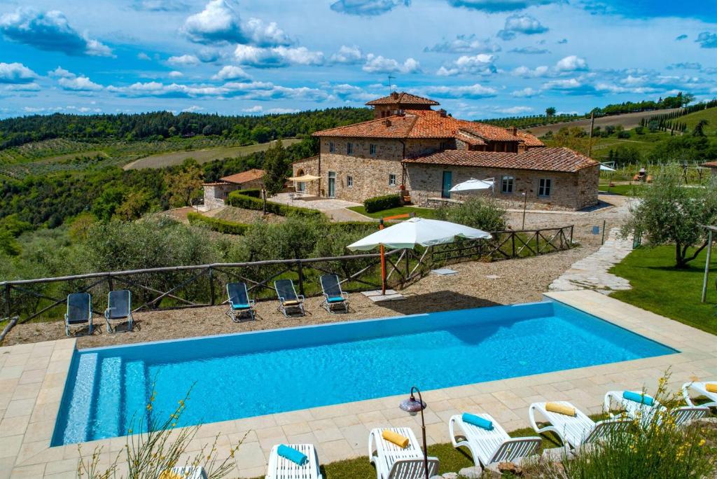 einen externen Blick auf eine Villa mit einem Pool in der Unterkunft Agriturismo Concadoro in Castellina in Chianti