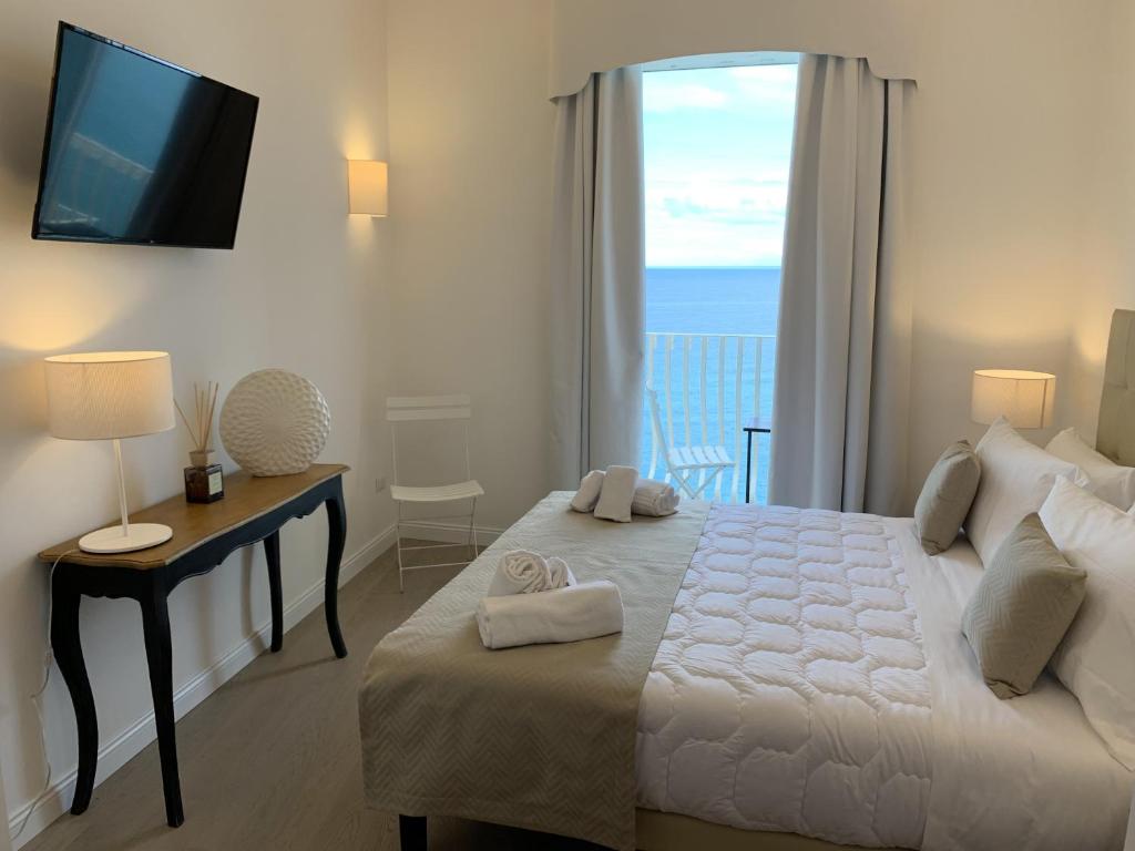 sypialnia z dużym łóżkiem i widokiem na ocean w obiekcie Domus Centro Tropea w Tropei
