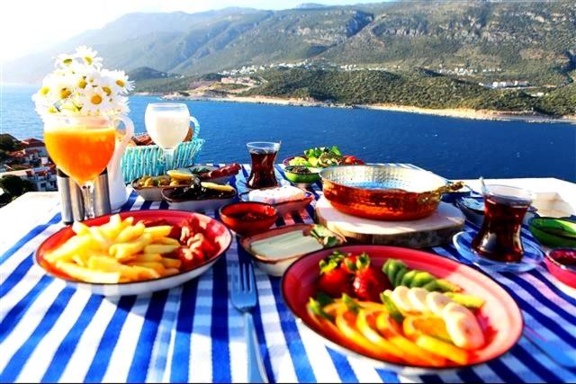una mesa azul y blanca con platos de comida. en Düşler Evim Butik Otel en Kas