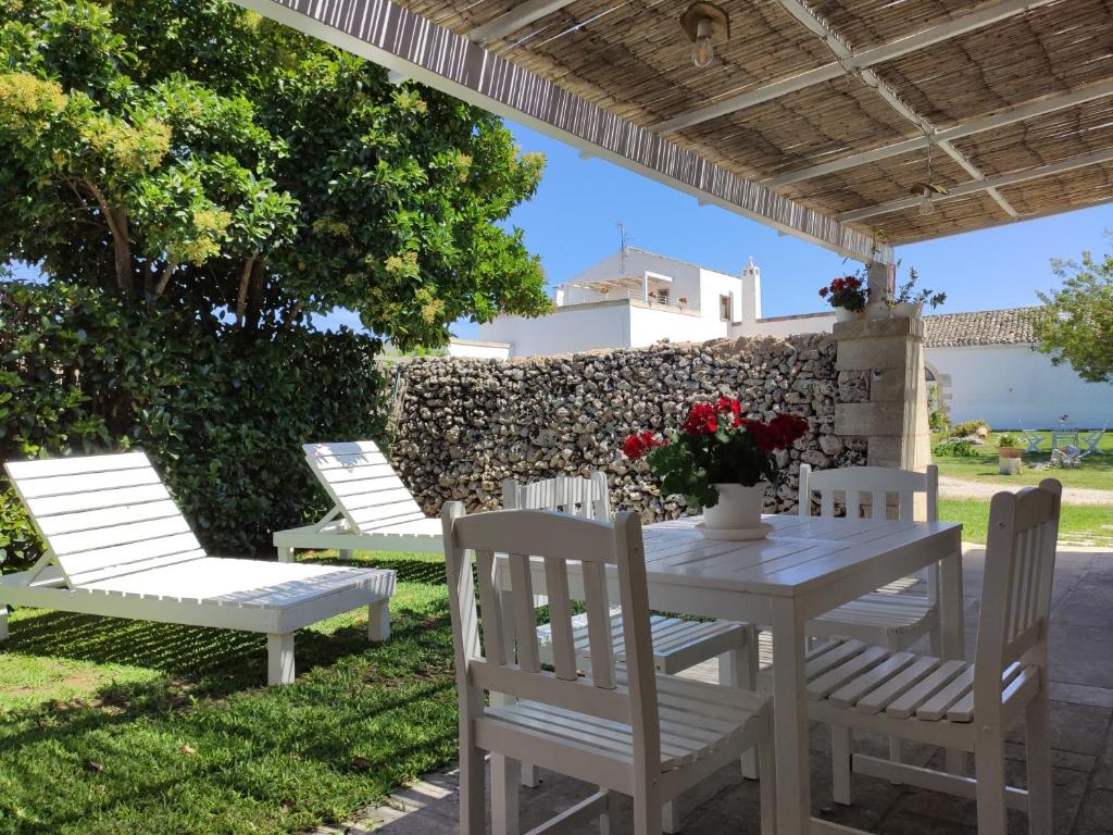 uma mesa e cadeiras debaixo de uma pérgola em Masseria Salentina Costarella em Borgagne