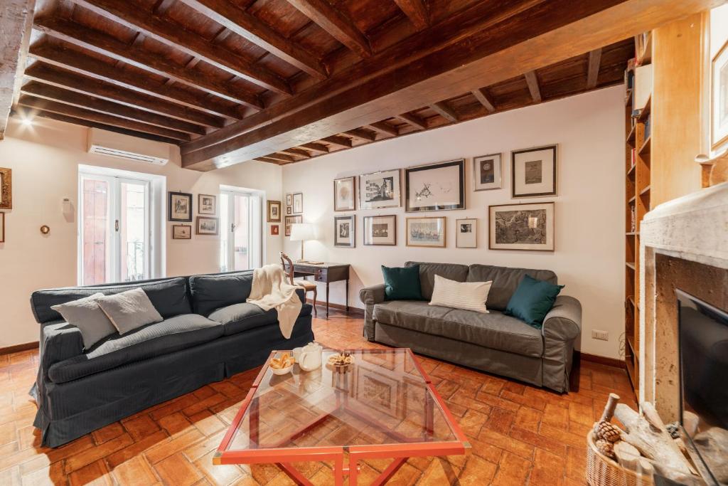 a living room with a couch and a table at Domus Quiritum Charming, Appartamento d'Epoca a Campo de' Fiori in Rome