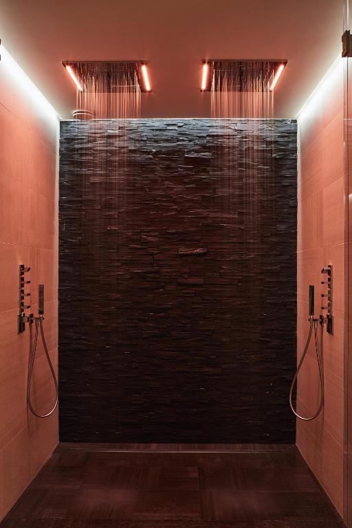 a bathroom with a shower with a brick wall at Villa Cosy, hotel & spa in Saint-Tropez