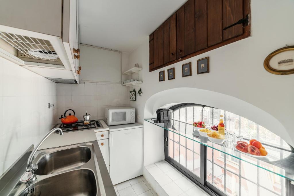 a small kitchen with a sink and a window at Domus Quiritum Charming, Appartamento d'Epoca a Campo de' Fiori in Rome