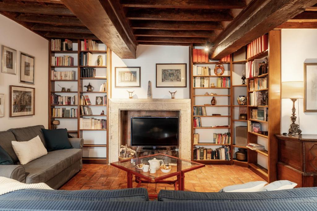 a living room with a couch and a fireplace at Domus Quiritum Charming, Appartamento d'Epoca a Campo de' Fiori in Rome