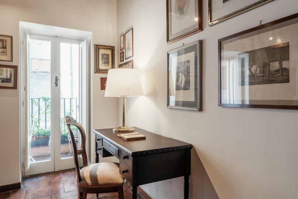 a desk with a lamp and a chair in a room at Domus Quiritum Charming, Appartamento d'Epoca a Campo de' Fiori in Rome