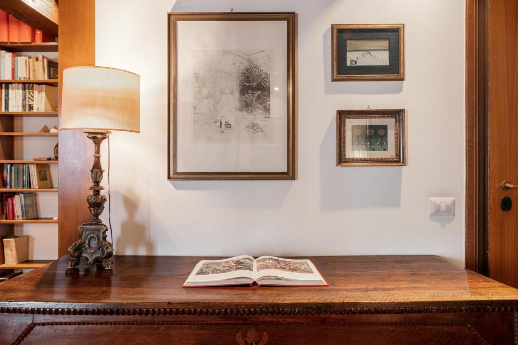 a lamp and an open book on a desk at Domus Quiritum Charming, Appartamento d'Epoca a Campo de' Fiori in Rome