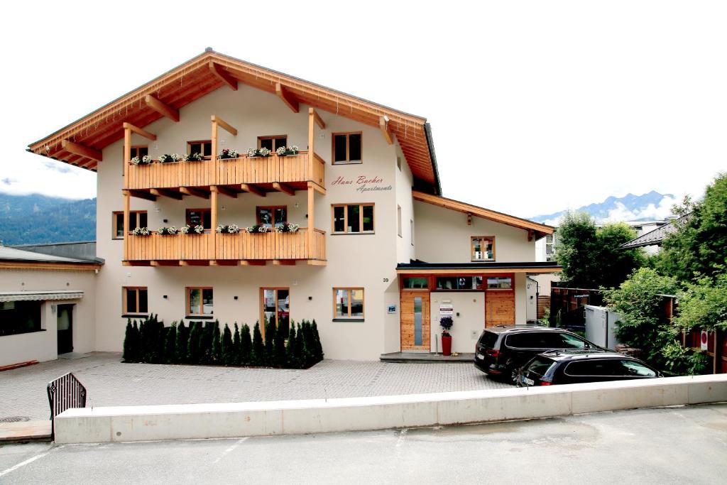 a large white building with a balcony and a car at Apartment Bacher in Zell am See
