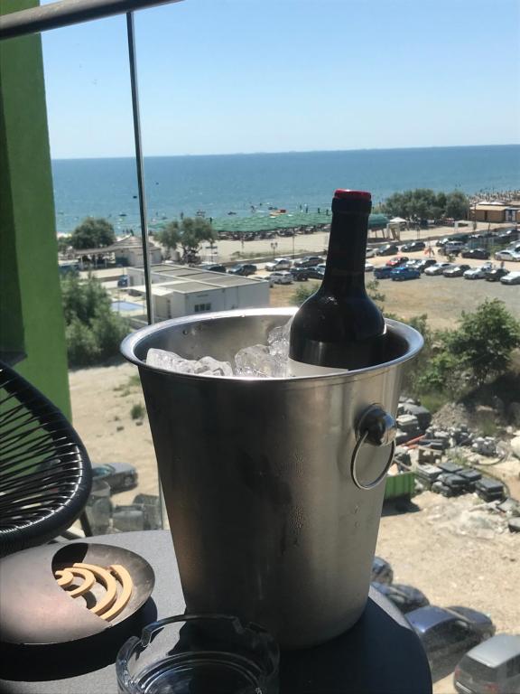 eine Flasche Wein in einem Eiskübel auf einem Balkon in der Unterkunft Alezzi Sunwaves in Mamaia Nord – Năvodari