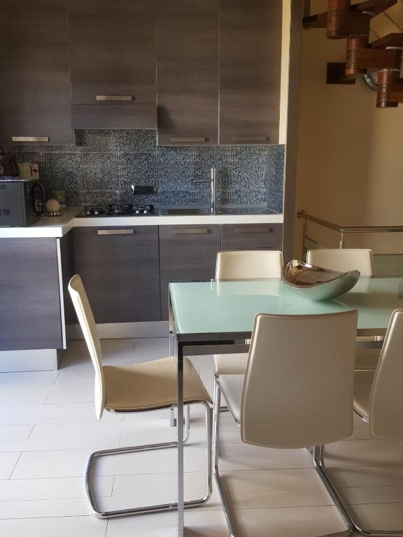 a kitchen with a green table and chairs at Appartamento moderno in Le Castella