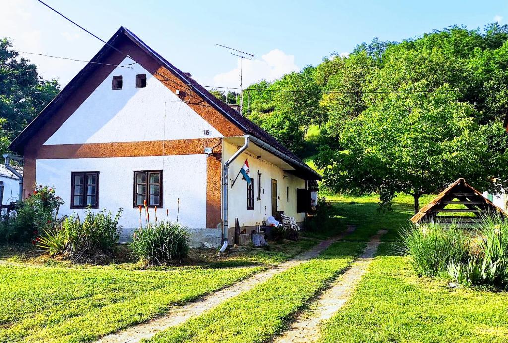 Lovászhetény的住宿－Pusztakisfalu Vendégház，一间白色的小房子,有 ⁇ 帽屋顶