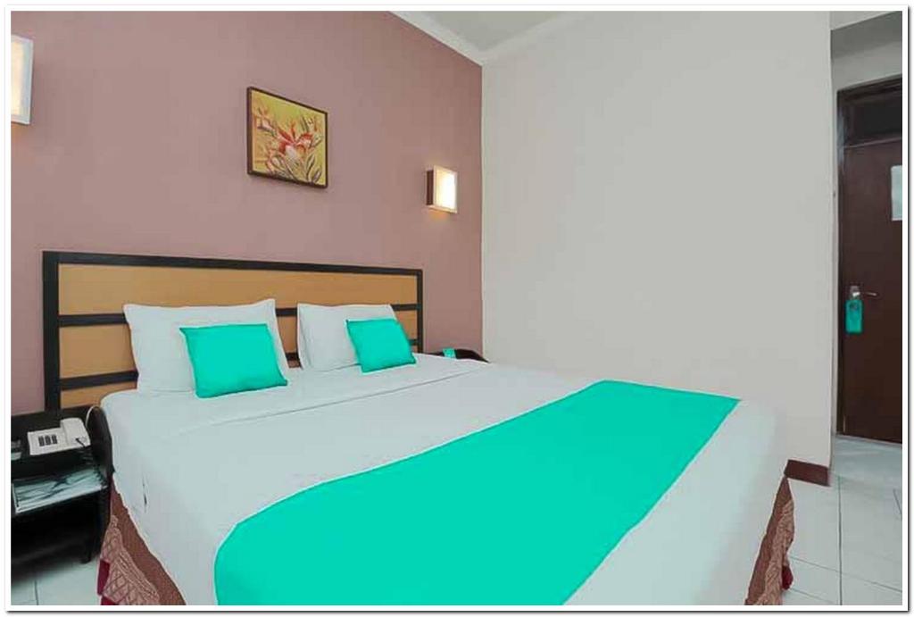 Giường trong phòng chung tại Hotel Lestari Near Lippo Plaza Mall Jember Mitra RedDoorz