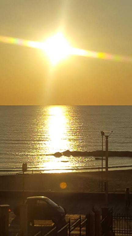 a sunset on the beach with the sun setting at Letizia Apartment in Crotone