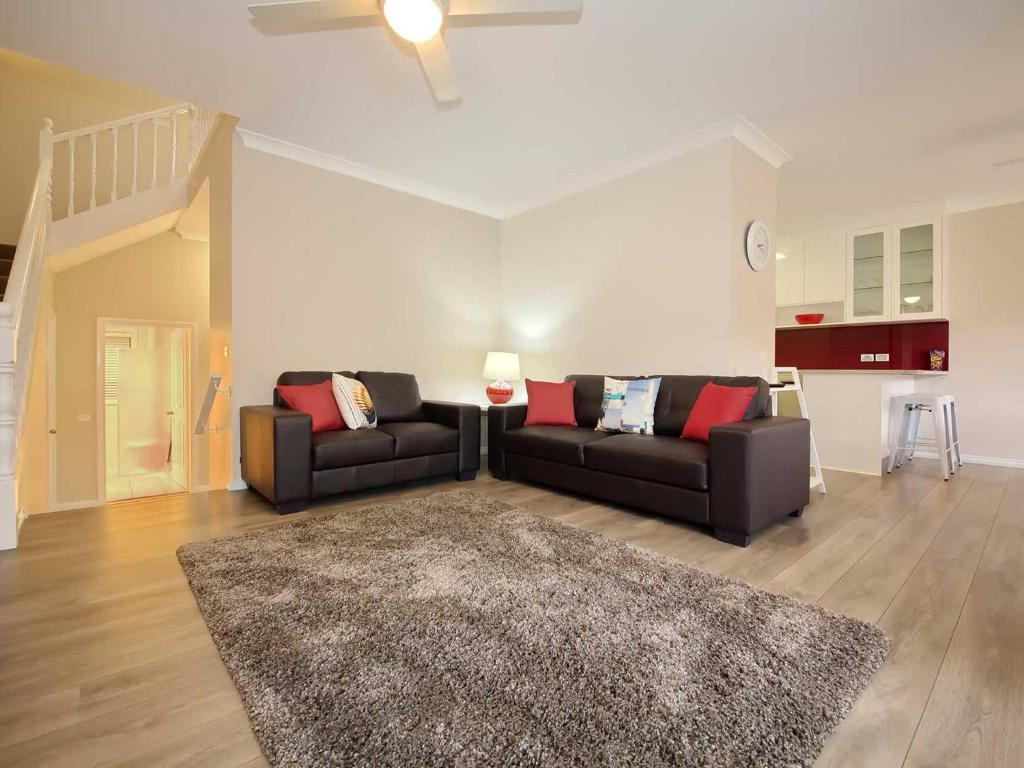 a living room with two couches and a rug at Bushmans, 9 24 Tomaree Street - Spacious townhouse with air conditioning and close to Nelson Bay Town Centre in Nelson Bay