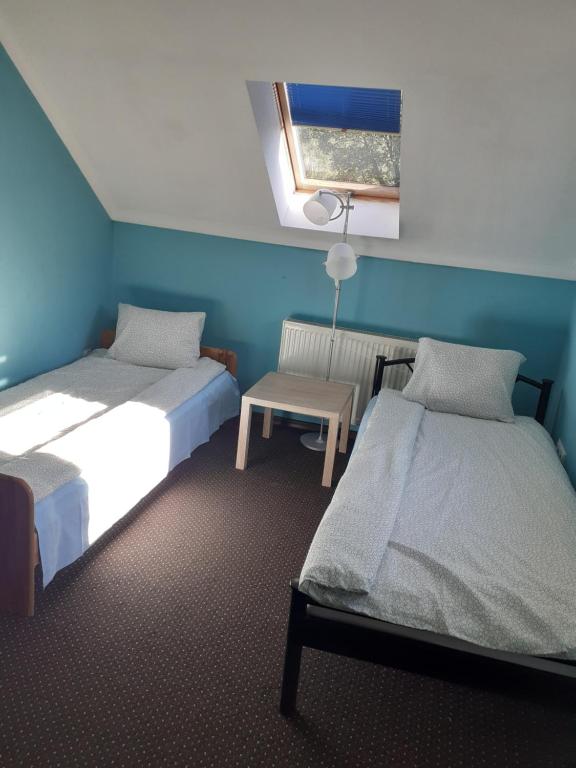 a room with two beds and a table and a window at Apartament 107 B, Noclegi pod dobrym Aniolem in Kudowa-Zdrój