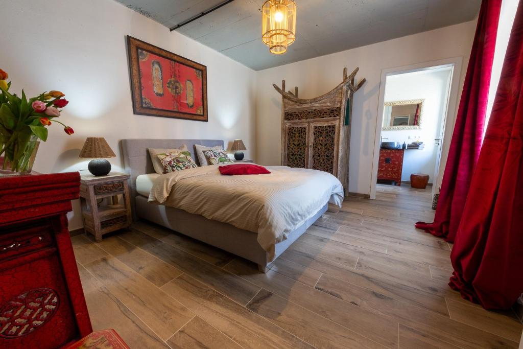 Niederpallen的住宿－Green & Breakfast Chambre Satita，一间卧室配有床和红色窗帘