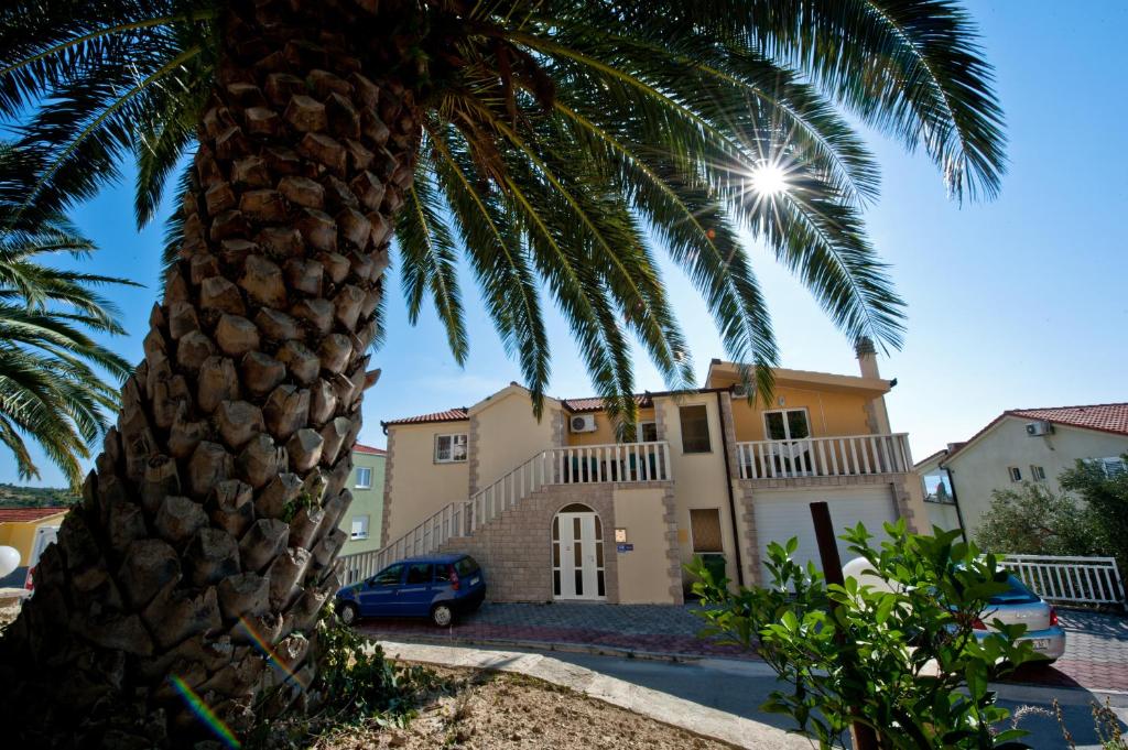 a palm tree in front of a house at Apartmani Ibolja in Promajna
