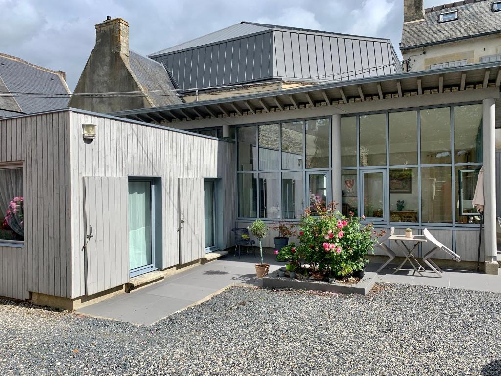 uma casa branca com muitas janelas em Tiny house au cœur de Bayeux em Bayeux