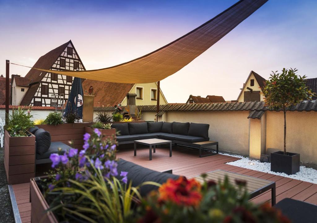 a patio with a couch and a table on a roof at Hotel Gasthof Krone in Spalt
