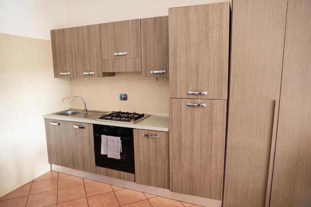 a kitchen with wooden cabinets and a stove top oven at Villa Mercedes in Rome