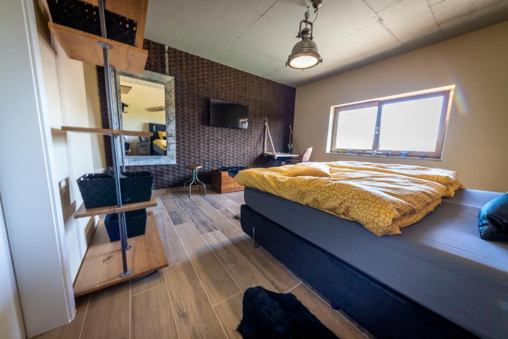 een slaapkamer met een groot bed en een spiegel bij Green & Breakfast Havilland in Niederpallen