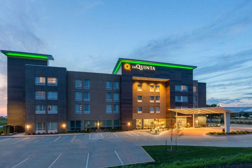 a hotel with a parking lot in front of it at La Quinta by Wyndham Altoona Des Moines in Altoona