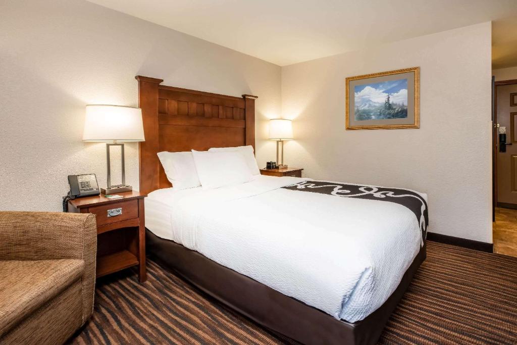 a hotel room with a large bed and a couch at La Quinta Inn by Wyndham Bend in Bend