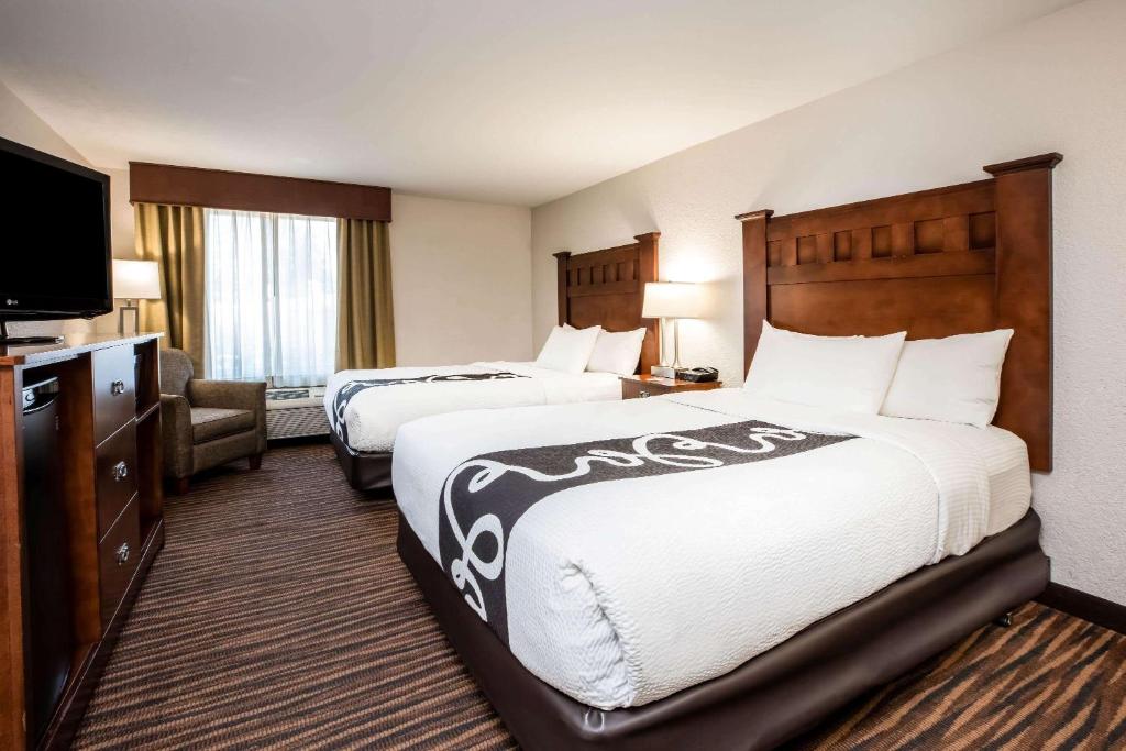 a hotel room with two beds and a flat screen tv at La Quinta Inn by Wyndham Bend in Bend